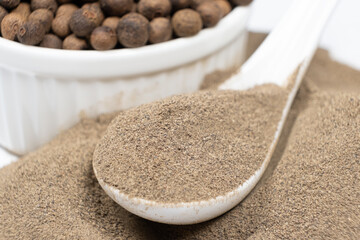 Ground black pepper and peppercorns close-up.