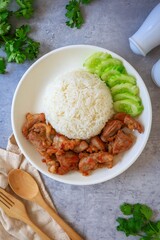 Home made Fried pork with rice and cucumber  in a white plate , thai street food, top view