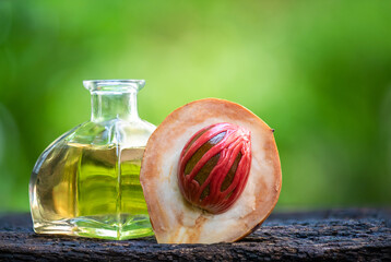 Fresh nutmeg and oil on natural background.