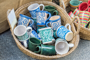 different painted and decorated ceramic objects in a basket in a street market