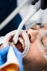 Airflow teeth polishing in dental clinic. Dentist polishes teeth enamel using dental airflow...