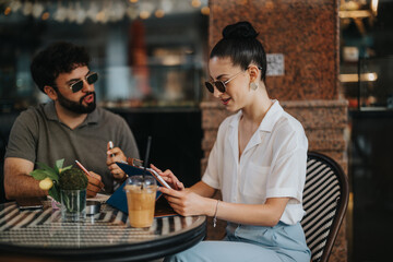 Two business partners strategizing and discussing over a new business project in a modern coffee shop, analyzing data and planning strategy.