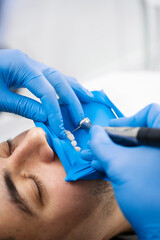 Dentist uses rubber dam to isolate teeth for drilling. Teeth preparation in dental dam before...