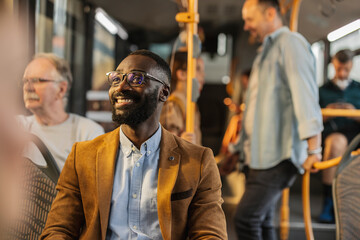 Man smiling on a bus during a full bus ride at rush hour © PintoArt