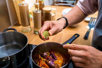 Chef at the kitchen preparing massaman curry with sweet potato and many spices
