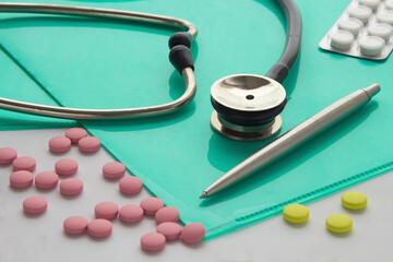 Stethoscope and pills on the desktop