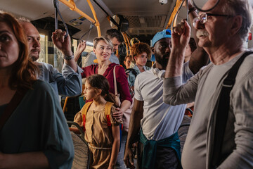 Multigenerational group of travelers on a busy electric eco-bus
