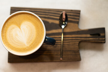 top view of cappuccino in a cup on a wooden board