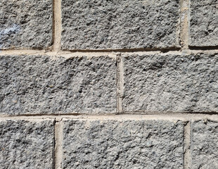 Granite  surface texture, background. The wall is made of gray stone blocks.