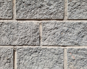 Granite  surface texture, background. The wall is made of gray stone blocks.