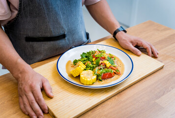 Chef at the kitchen preparing spicy glass noodle salad