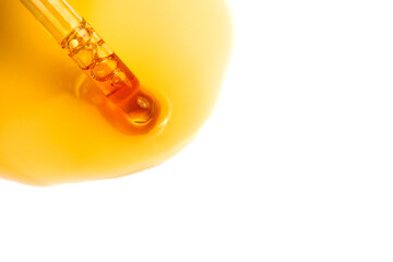 Sample of yellow cosmetic serum or oil with a pipette on a white background. Beauty product. Skin care. Vitamin, Ceramides, peptides. Acid peeling. Hyaluronic acid