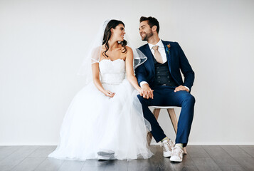 Naklejka premium Bride, groom or smile on white background on chairs for marriage, wedding with soulmate and trust. Happy couple, unity or studio with hand holding for commitment to love, together in Chicago