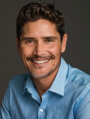 Fototapeta premium Professional Headshot of a happy, smiling Hispanic man in a Blue Shirt.