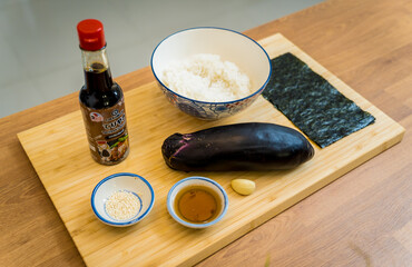 Cutting board with ingredients for preparing grilled eggplants with garlic