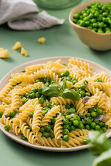 Fusilli pasta with steamed peas and basil served on plate