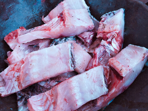 Fish pieces in a frying pan fishmeat fishflesh cut sliced machhalee, raw pesce, pescado, piece closeup image stock photo
