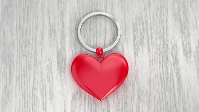 Keyring with a shiny red heart on a wood background
