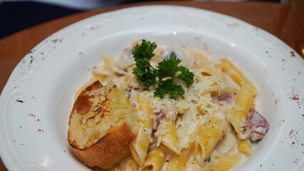 Creamy pasta with mushrooms, bacon, and a side of garlic bread.