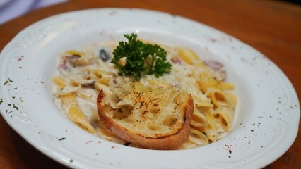 Creamy pasta with mushrooms, bacon, and a side of garlic bread.