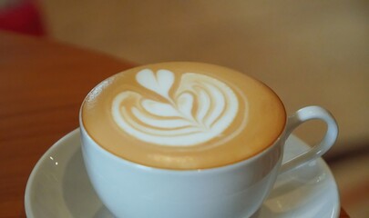 A white cup of coffee with latte art.
