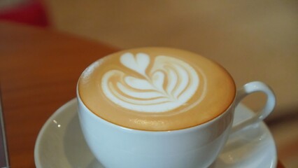 A white cup of coffee with latte art.