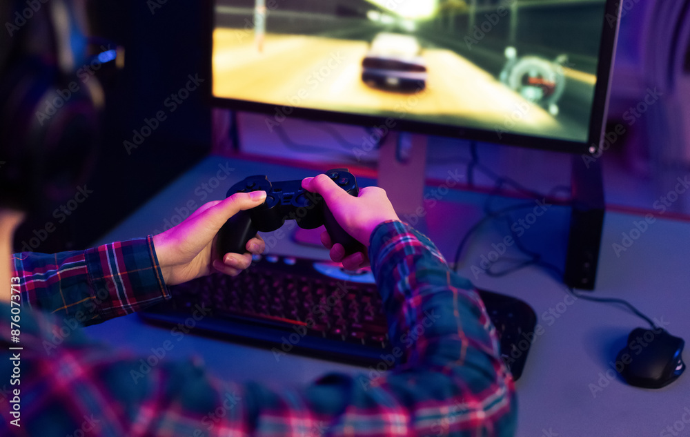 Aufkleber This image shows a gamer playing a racing video game at their computer desk. The gamer is wearing a plaid shirt and using a black video game controller. The computer monitor is displaying racing game