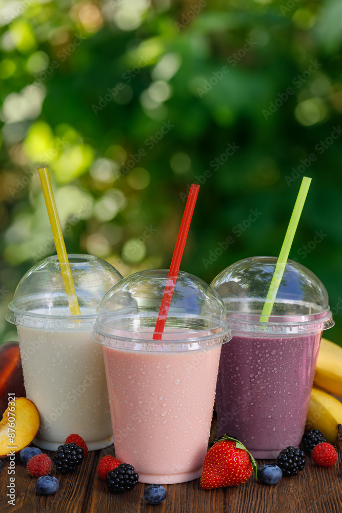 Canvas Prints set of different flavor milkshakes or smoothie in disposable plastic glasses on wooden table outdoor