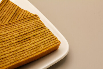 Traditional Indonesian sweet Lapis layer cake on a gray background.