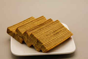 Traditional Indonesian sweet Lapis layer cake on a gray background.