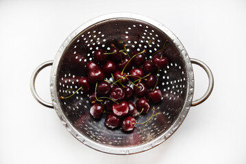 Washing cherries in a colander. Freshly washed cherries. Red berries.