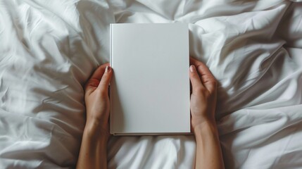Blank book mockup with cover. Hand holding white paper template. Woman s background design for empty female business. Cozy warm bed with pillow view. Hold closed diary page