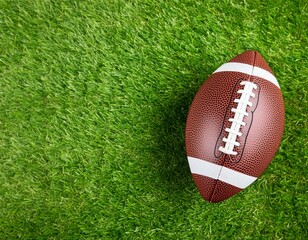 Obraz premium Ball for American football on fresh green field grass, top view. Space for text 
