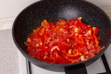 Tomato and pepper sauce in a wok on the stove