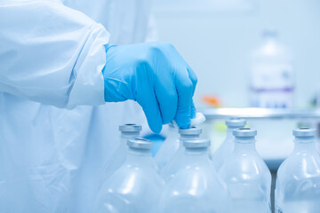The doctor wearing blue gloves and uses a cotton swab to wipe off the normal saline solution before...