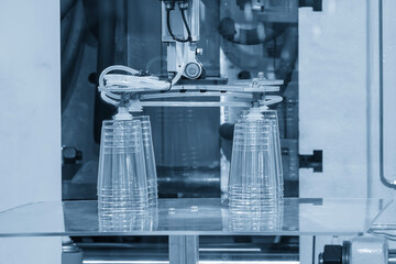 The plastic drinking glass part gripping by  vacuum robotic system from injection machine.