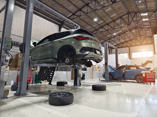 A car is raised up using a lift inside a service for maintenance