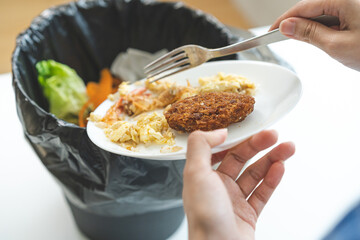 Compost from leftover food, refuse asian young housekeeper woman, girl hand using fork scraping waste from dish, throwing away putting into garbage, trash or bin..Environmentally responsible, ecology.