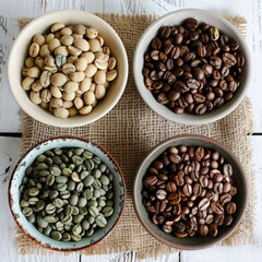 Fototapeta premium Coffee beans in saucers on wooden background. Ai generated