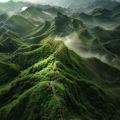 An awe-inspiring shot of the Great Wall of China winding through lush green mountains, with mist rising from the valleys and the wall stretching into the horizon