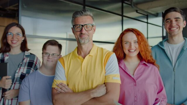 Ceo standing with crossed hands surrounded by coworkers