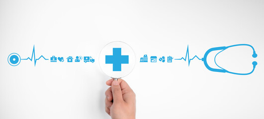 Person's hand holds a magnifying glass focus on plus icon symbolizing healthcare and medical services. This concept illustrates health insurance and the access to comprehensive welfare health benefits