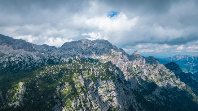 An awe-inspiring aerial view of the Slovenian Alps, featuring the majestic peaks of Vi&scaron;evnik, Jezerca, and Veliki Dra&scaron;ki vrh. These stunning mountains offer breathtaking hiking trails