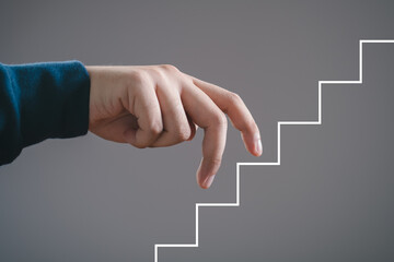 Fingers walking up drawn staircase concept, symbolizing progress, success, growth, ambition, and career development.