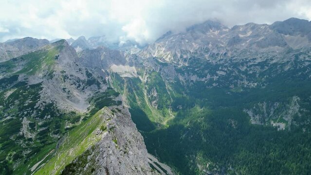 An awe-inspiring aerial view of the Slovenian Alps, featuring the majestic peaks of Vi&scaron;evnik, Jezerca, and Veliki Dra&scaron;ki vrh. These stunning mountains offer breathtaking hiking trails