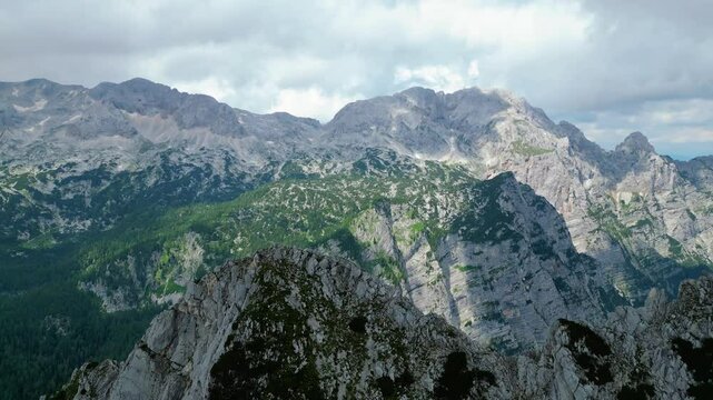 An awe-inspiring aerial view of the Slovenian Alps, featuring the majestic peaks of Vi&scaron;evnik, Jezerca, and Veliki Dra&scaron;ki vrh. These stunning mountains offer breathtaking hiking trails