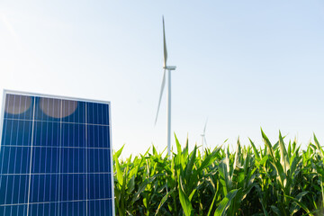 Solar panel and wind turbine on an agricultural field. Sustainable energy.