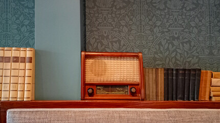 vintage retro old bronze radio on a shelf with old books