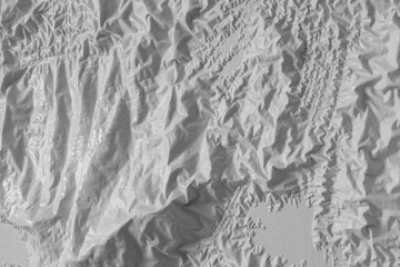 White Wavy Paint Peeling Off The Painted Surface. White Surface Painted With Paint Stripper. Irregular Crumpled White Background Looks Like Map Of Mountainous Terrain In 3D. White Folded Layout.