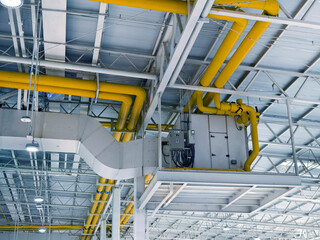 Ceiling with ventilation pipes and lights in industrial building